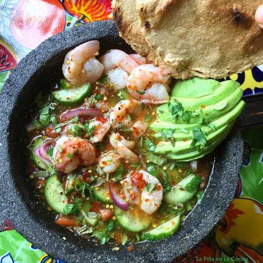 AGUACHILE MACHO AL MOLCAJETE DE CAMARON CON CHILTEPIN CILANTRO, ACEITE DE AJONJOLÍ, PEPINO Y AGUACATE.